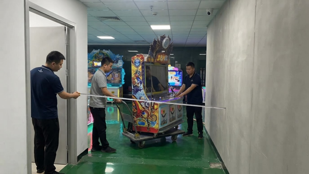 Delivery team checking doorway clearance for a large arcade machine