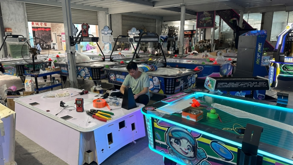 Technician checking an imported arcade machine during delivery and installation
