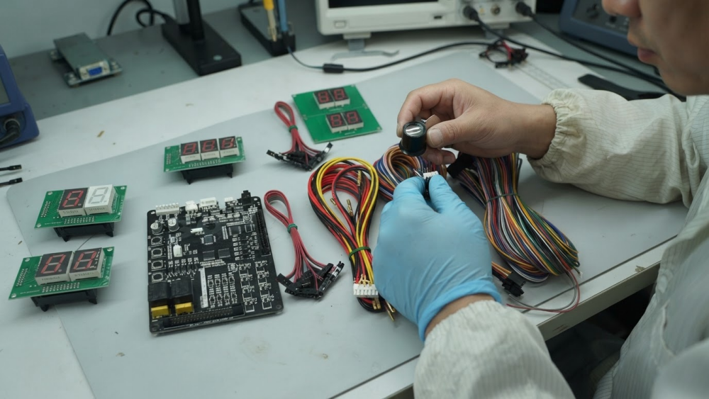 Technician checking arcade wiring harness crimps, terminals and insulation